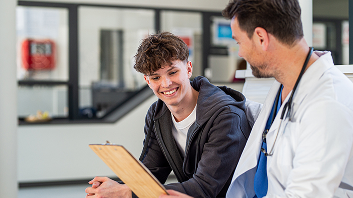 teenage boy talking with doctor
