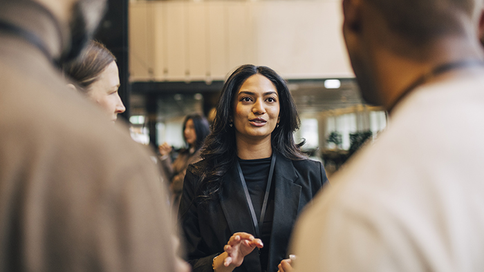woman speaking with two other people in a professional setting
