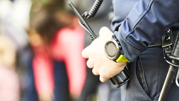 Security guard with hand on walkie-talkie